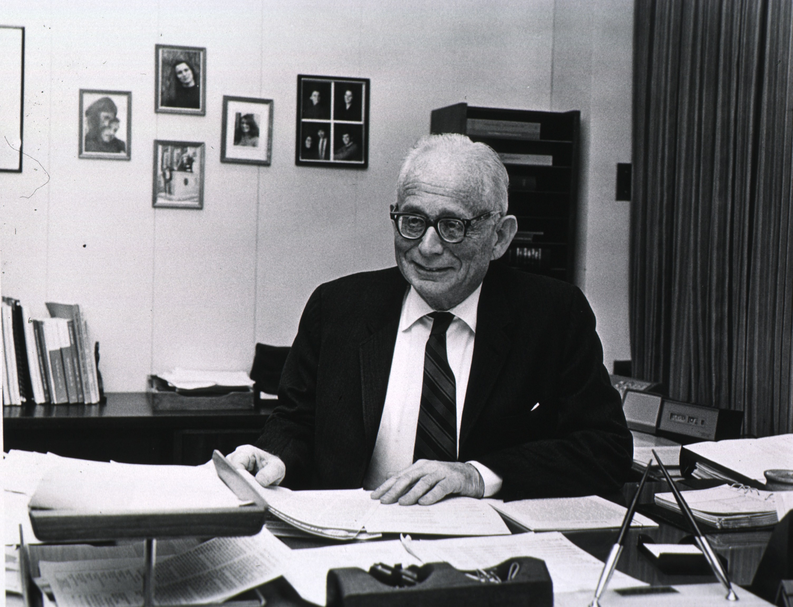 DeWitt Stetten sitting at his desk, looking to the left