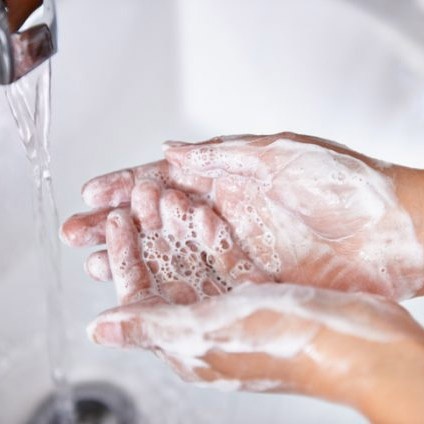 image of soapy hands being washed in water