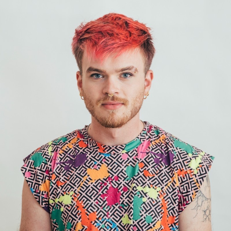 Man with mohawk haircut, brightly colored clothes, and nose ring