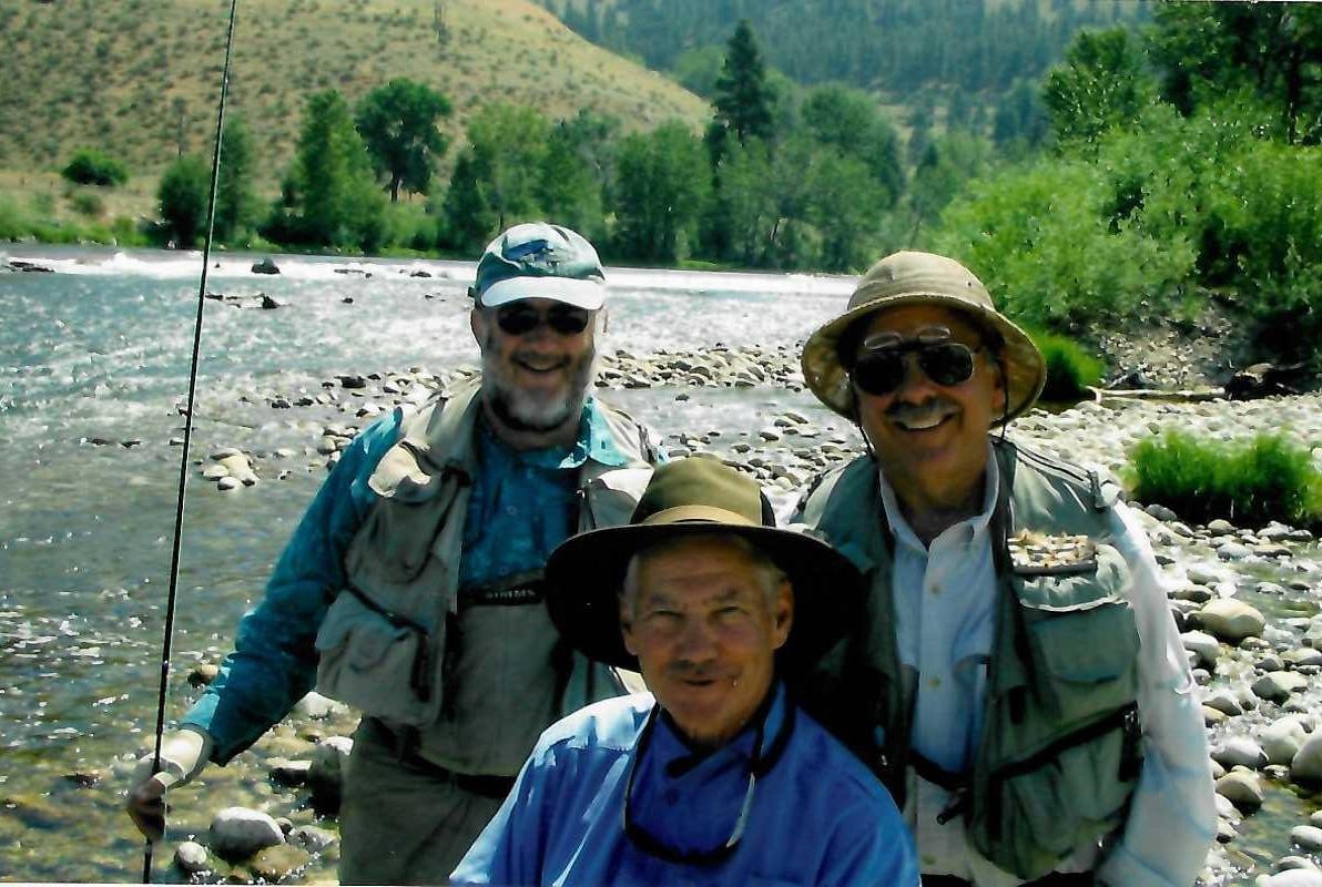 Irving Weissman, Stanley Falkow, and Marshall Bloom fishing. All are wearing hats and fishing vests as they stand in a mountain stream.