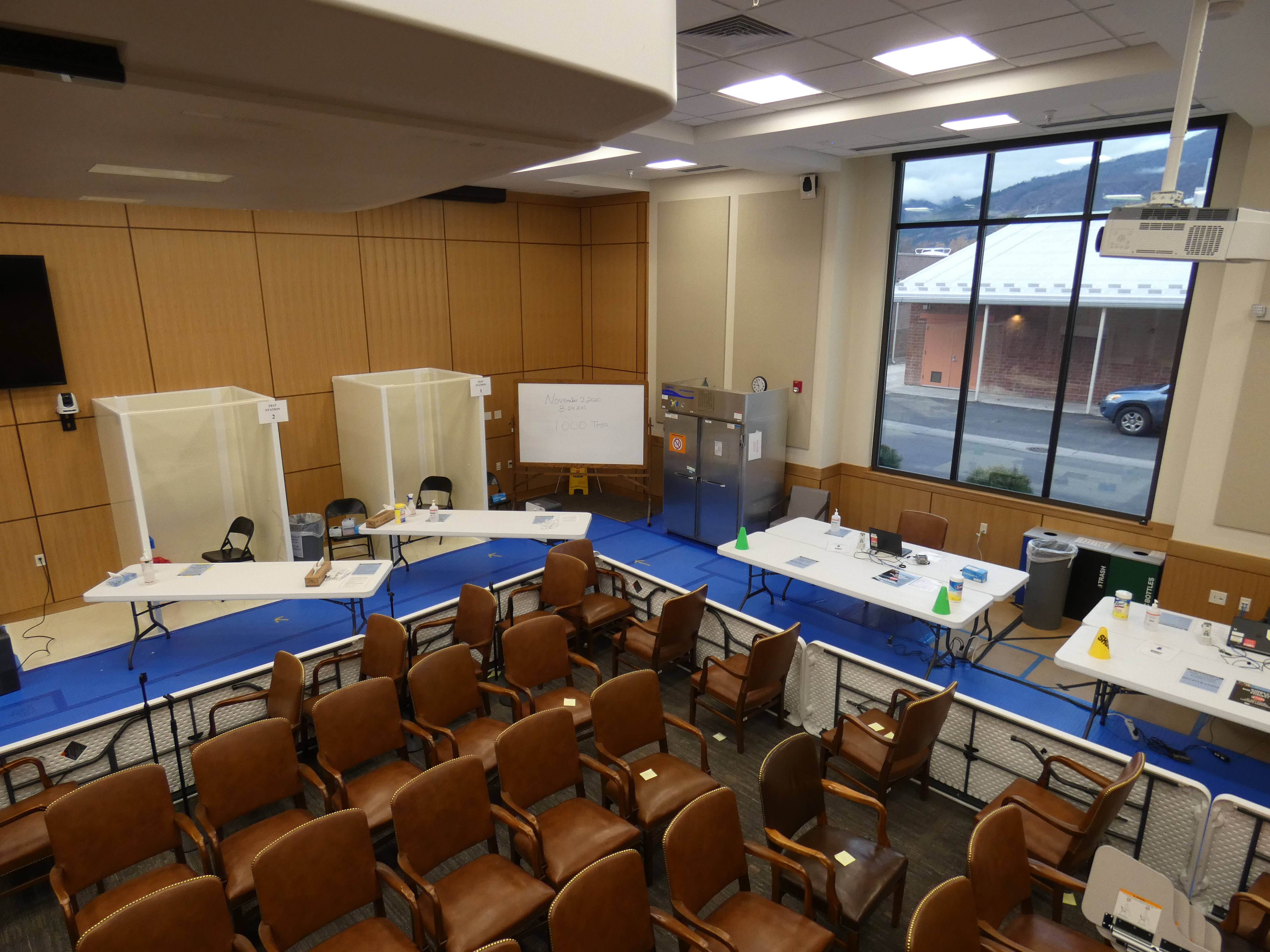 The RML COVID-19 testing and vaccination center, January 2020. A conference room with booths set up on the side and tables with clinical equipment, chairs piled in the middle.