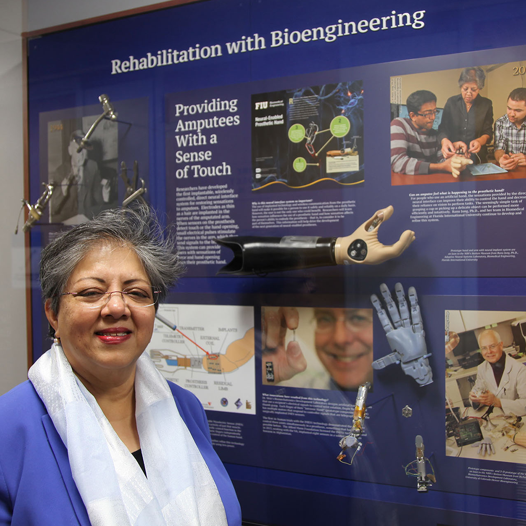 A woman is standing in front of the exhibit titled Rehabilitation with Bioengineering, which displays prosthetic devices, images and text