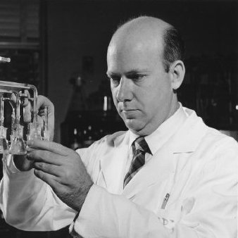 Photo of Earl Stadtman working with lab equipment