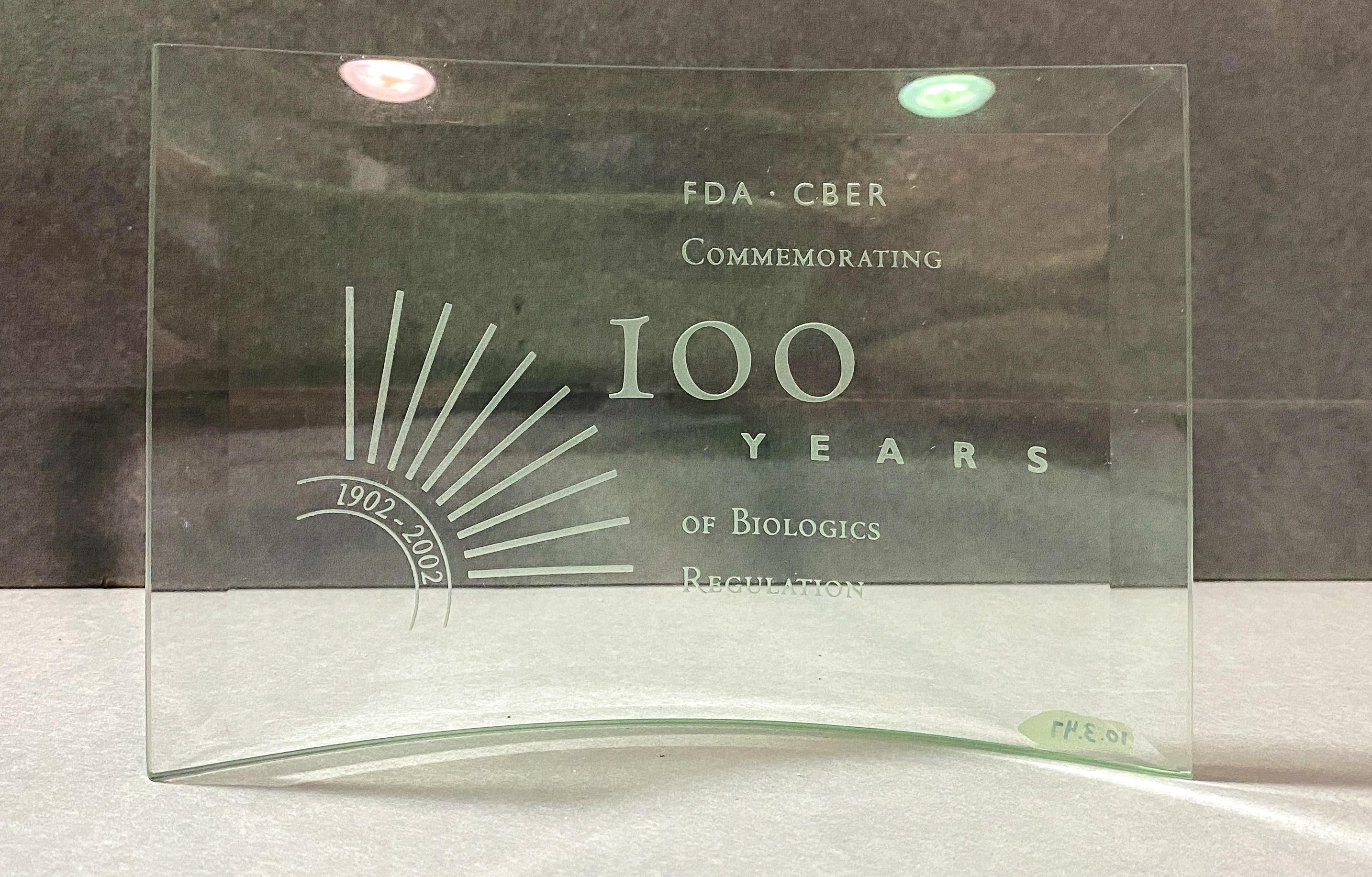 a photo of a glass rectangular award celebrating the 100th anniversary of the Center for Biologics Evaluation and Research