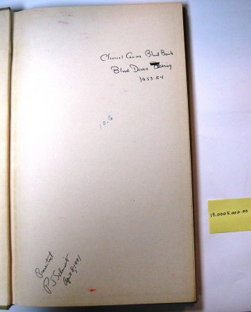 a government issues record book is opened to show notes written on the inside cover