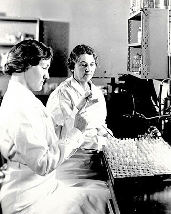 Dr Pittman and a colleague work in the lab with test tubes