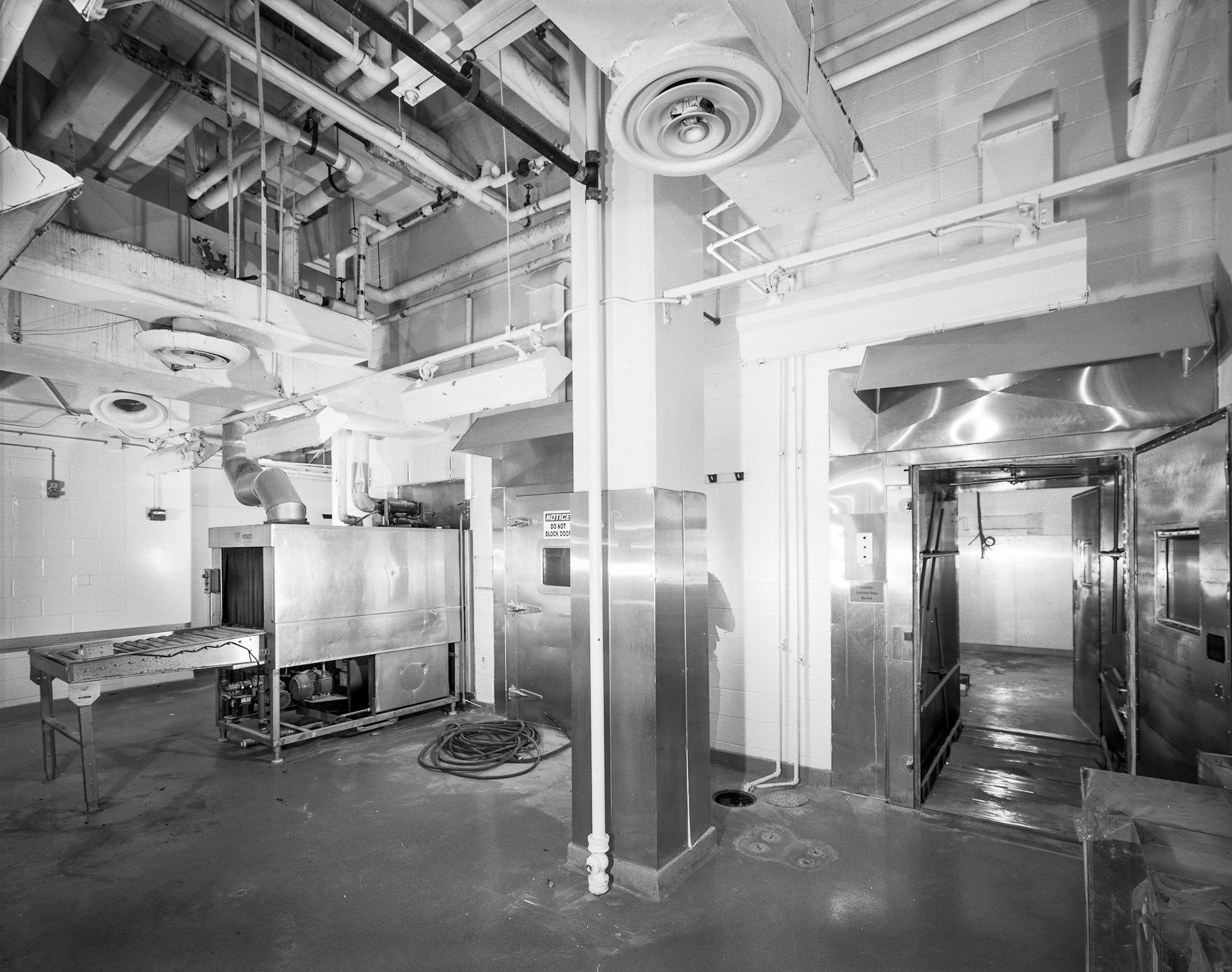 a black and white HABS photo of the animal cage washing room in the basement of building 29A. Stainless steel equipment on concrete floors