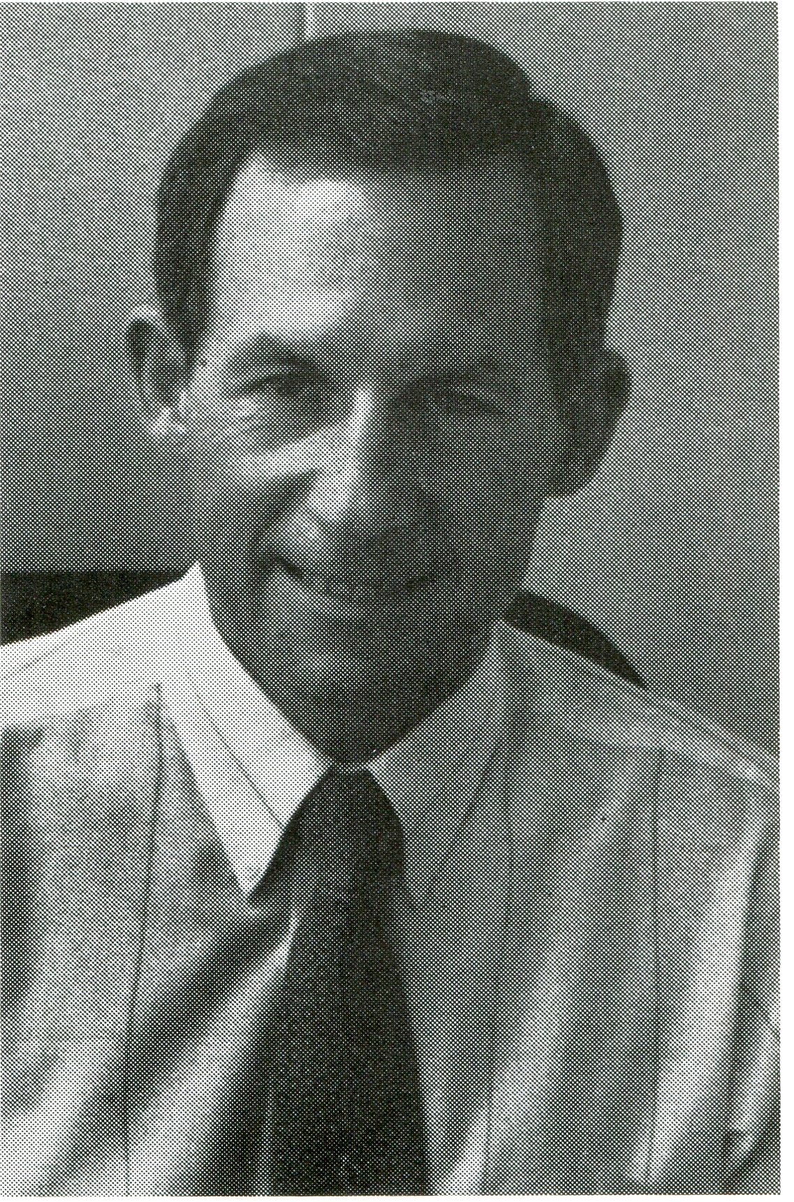 a black and white photo of a man in a shirt and tie