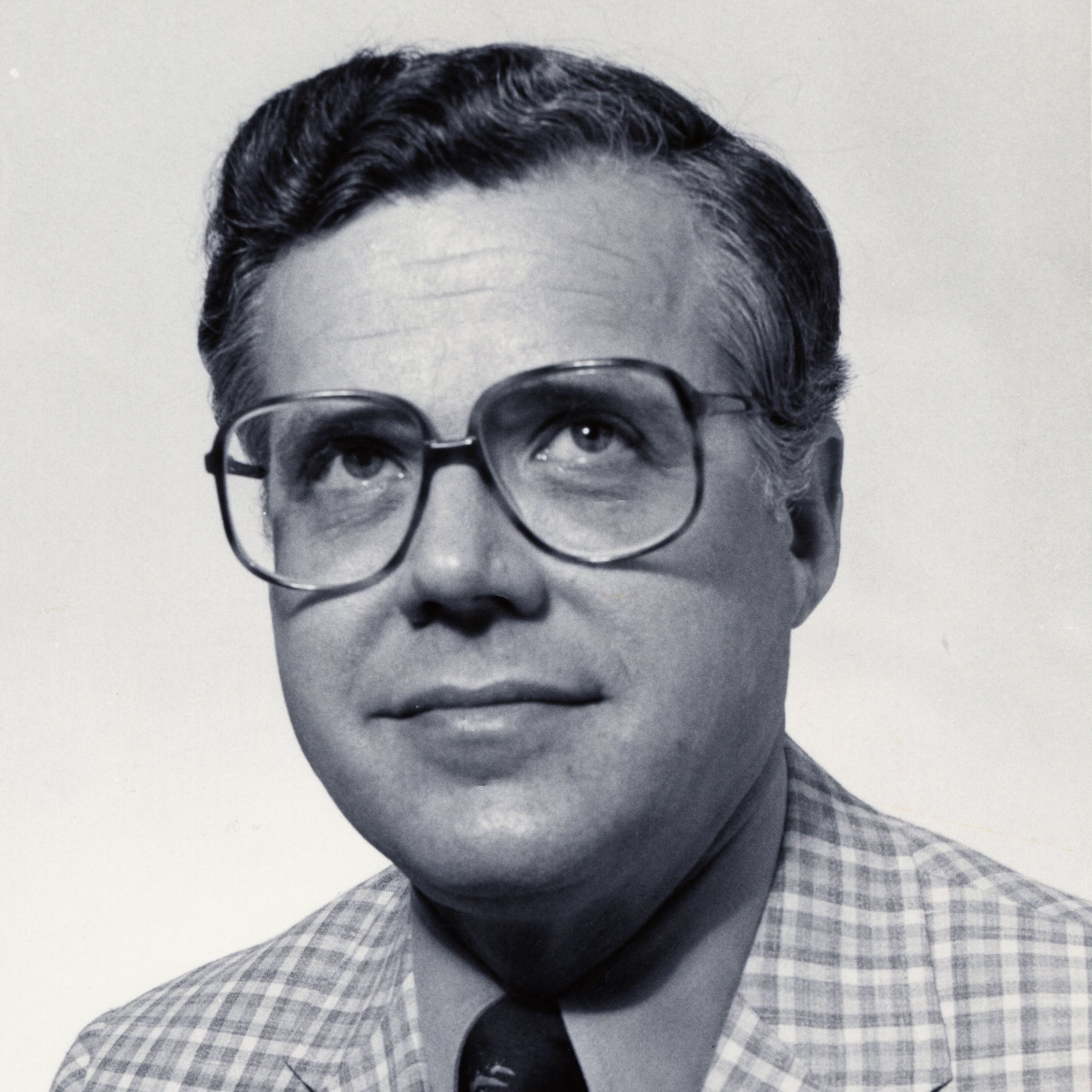 Professional photo of  Paul Parkman wearing glasses and a plaid suit