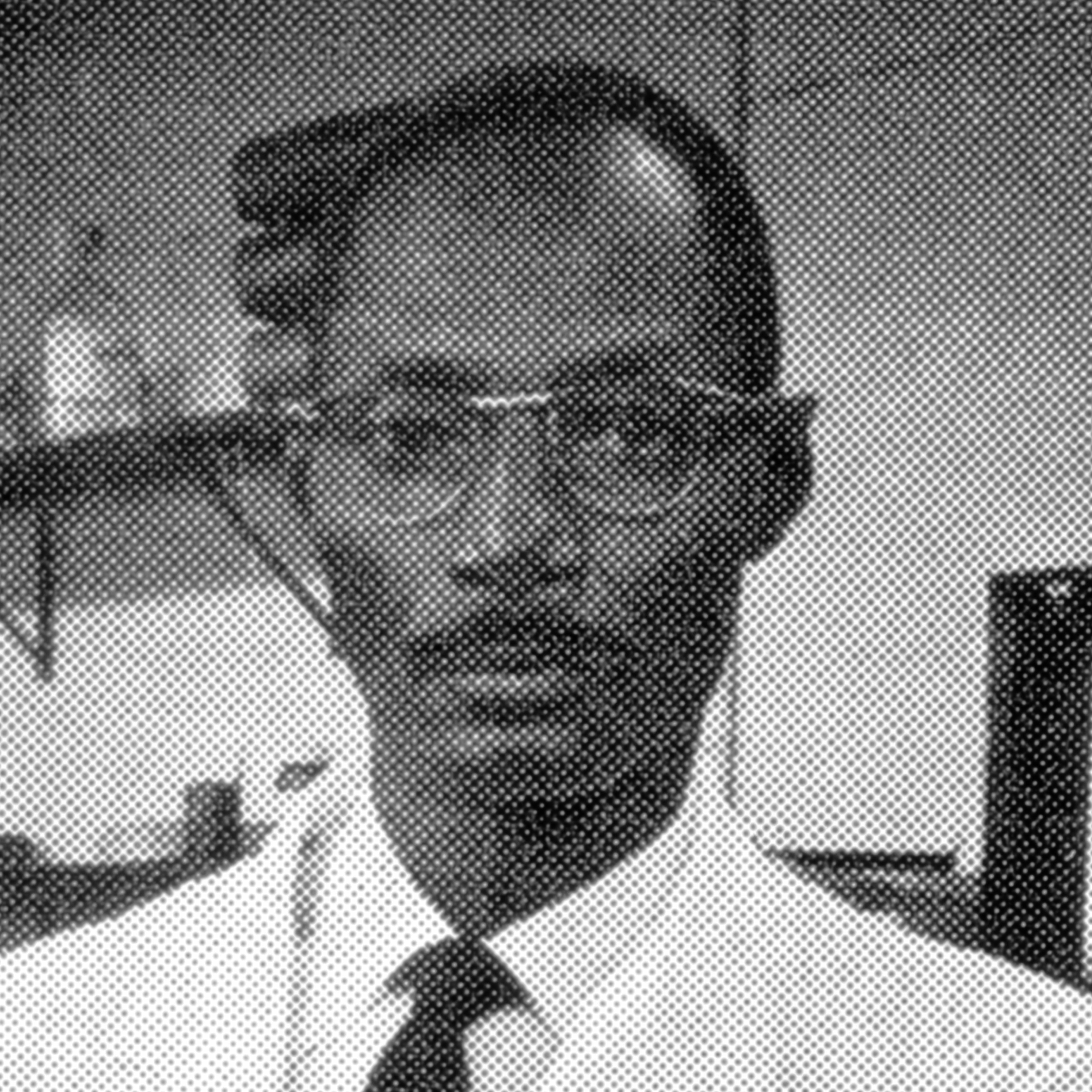Scan of a photo of George Rusten that was originally printed in the NIH Record. He's wearing glasses in the lab