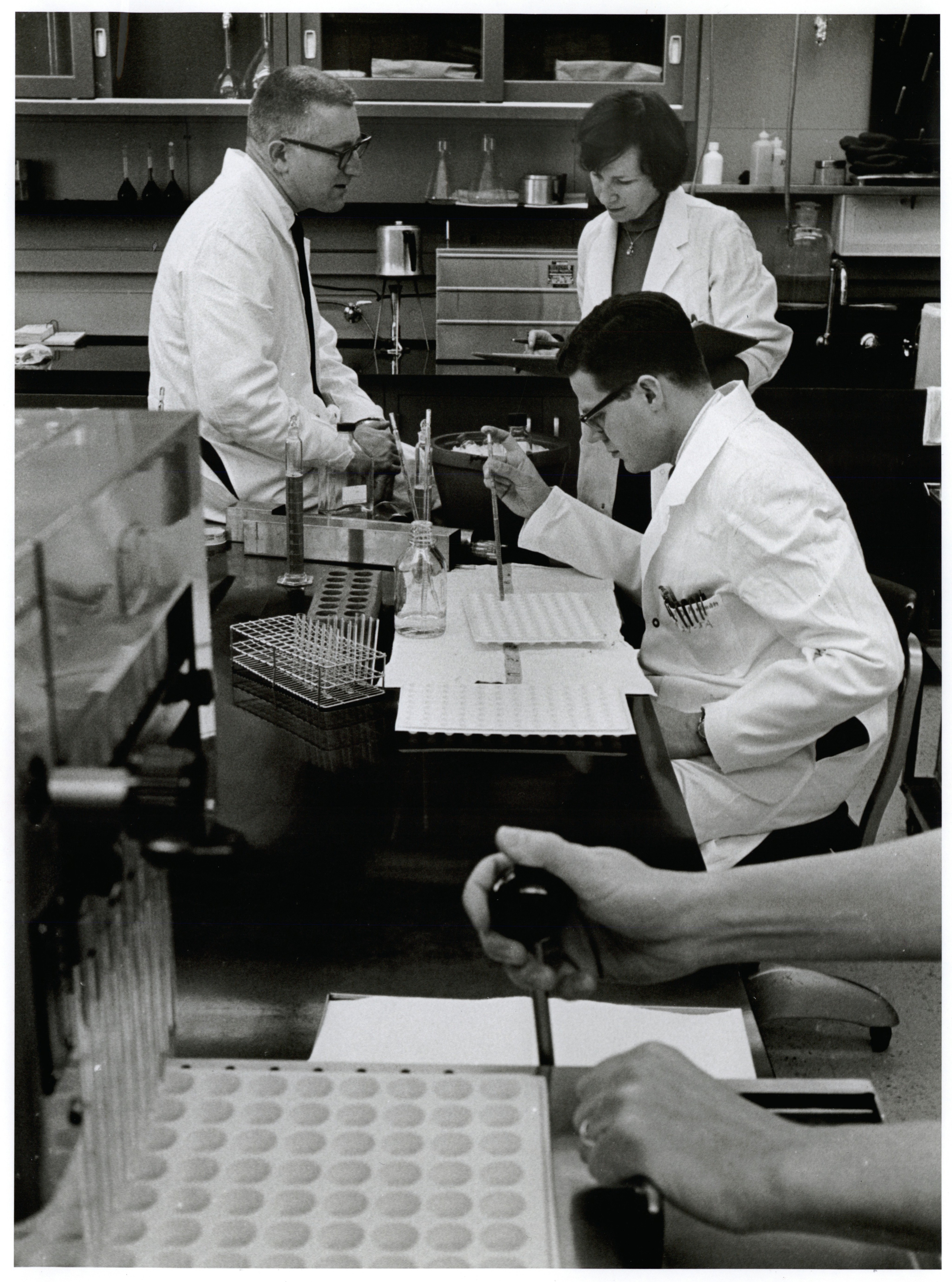 Three people in lab coats engaged in conducting research