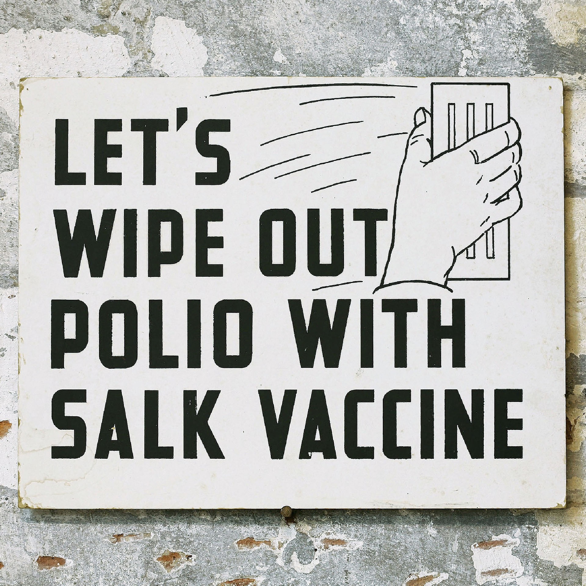 a sign on a masonry wall that says let's wipe out polio with the Salk vaccine