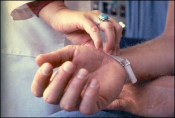 Healthcare worker takes a patient's pulse