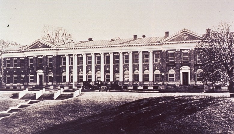 Large brick building with columns in the front and steps leading to the building